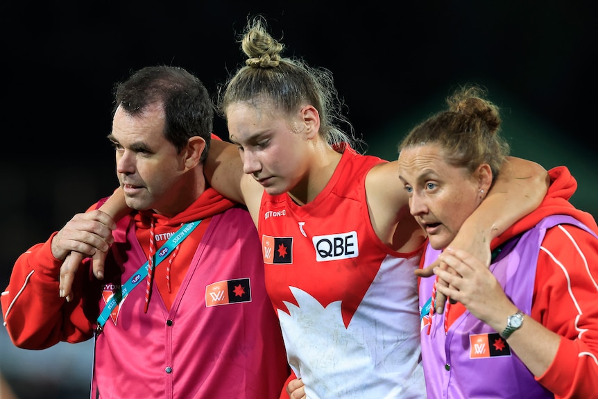 A Sydney Swans AFLW player is helped from the field after being injured.