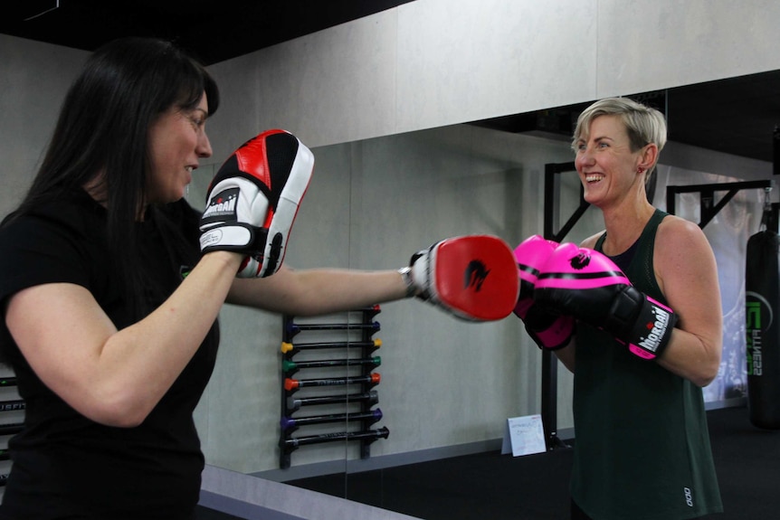 Two women engaged in boxing for a story about boxing benefits and how to get started.