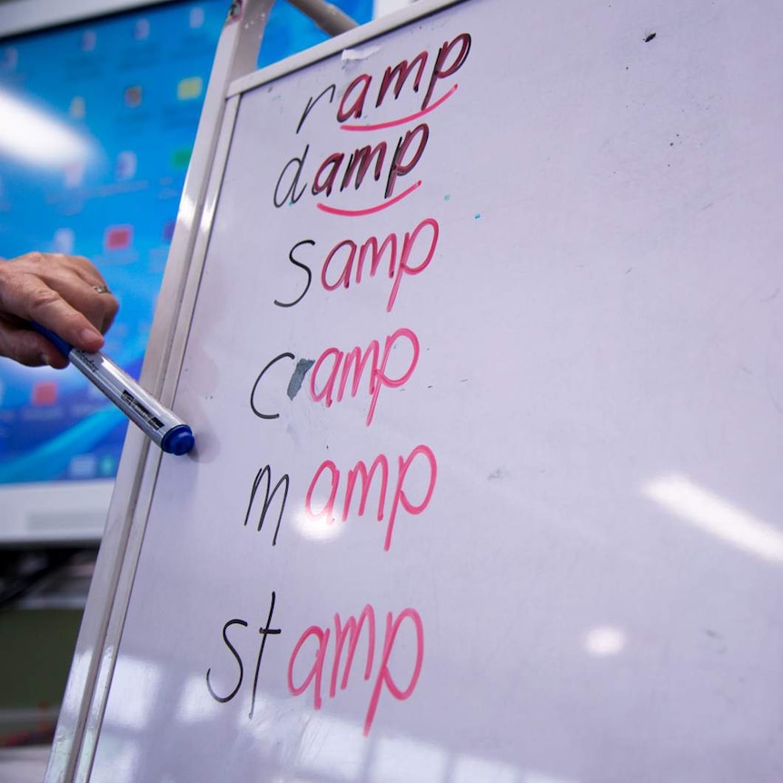 A whiteboard shows a number of words ending in 'amp' that children are encouraged to come up with.
