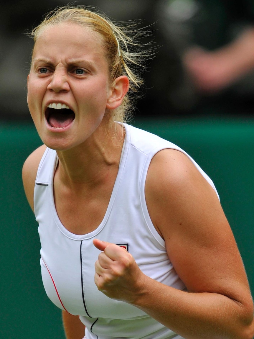 Jelena Dokic fist pumps and yells during a match.