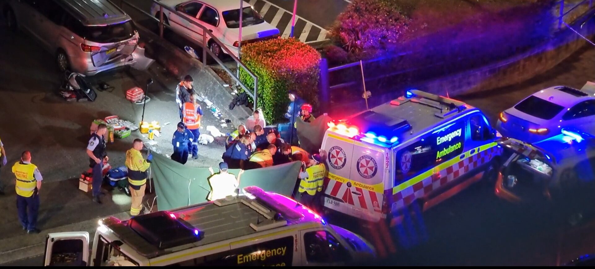 Uma ambulância e paramédicos tratam uma mulher que foi atropelada por um carro em Hornsby.