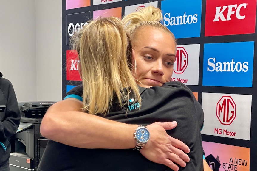 AFLW player Erin Phillips hugs another person.