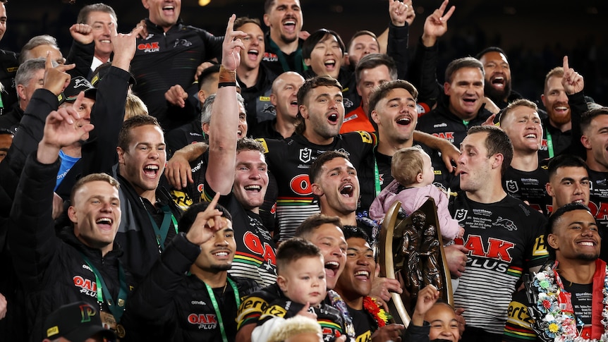 Penrith Panthers players celebrate with the NRL premiership trophy after the 2022 grand final.