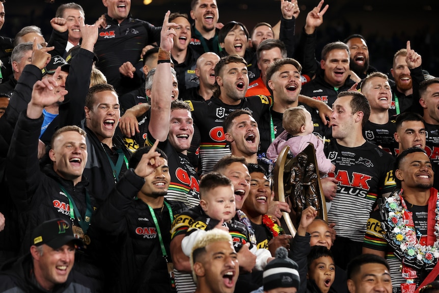 Penrith Panthers players celebrate with the NRL premiership trophy after the 2022 grand final.