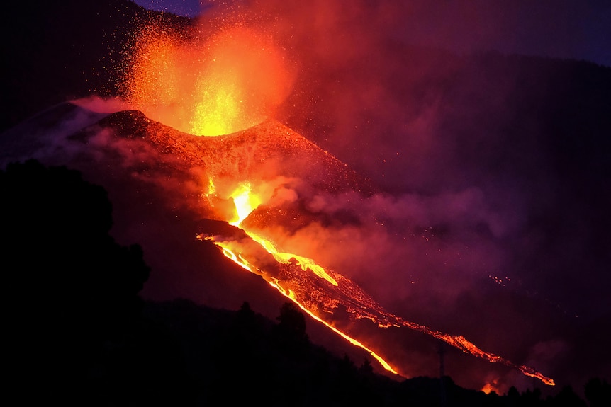 Lava roșie fierbinte se varsă din gura vulcanului La Palma, 2 octombrie 2021. 