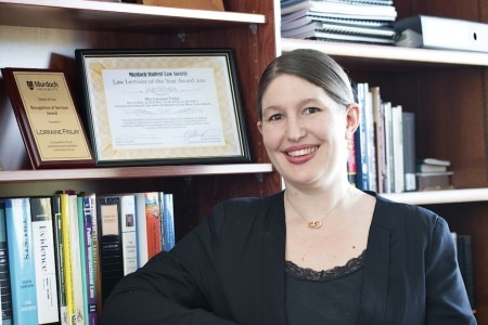 Woman in business suit standing in front of bookshelves