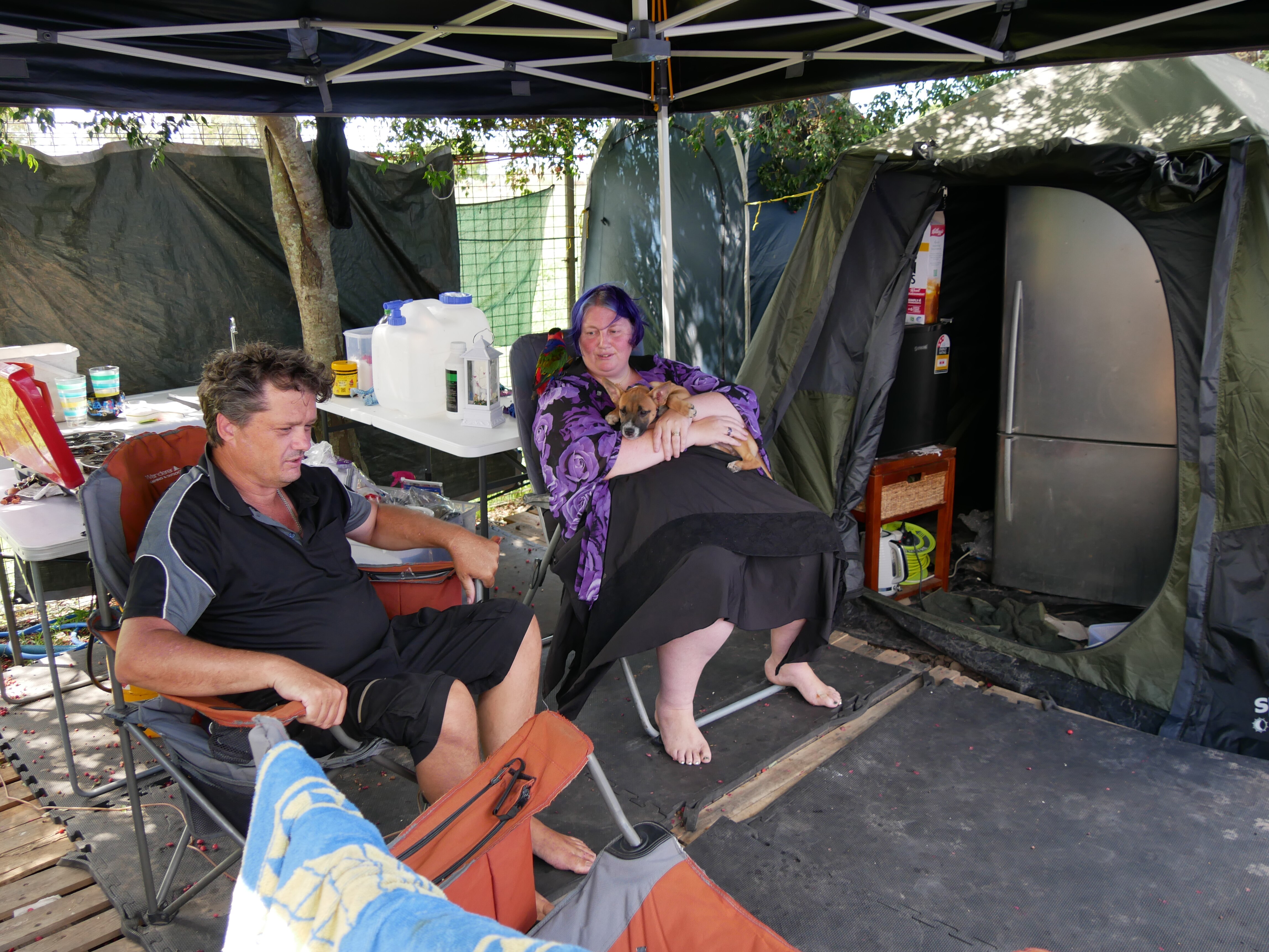 Un hombre y una mujer sentados en un camping.
