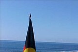 The red, yellow and black of the Aboriginal flag near a beach at Sandon Point in NSW