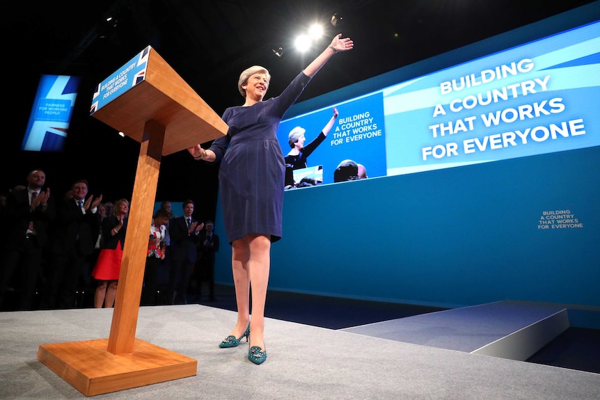 Theresa May addresses the crowd and waves from onstage