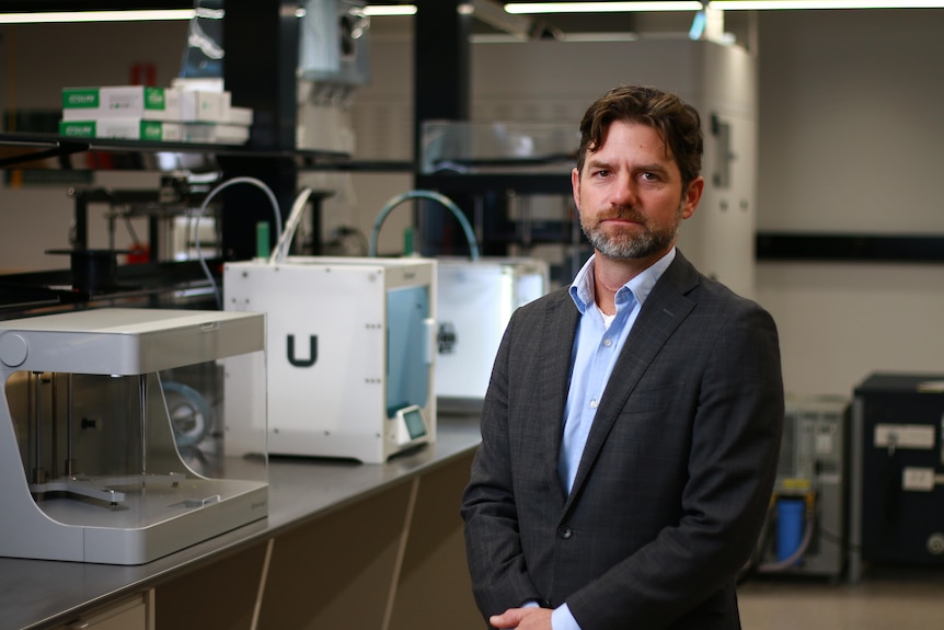 Michael Wagles wearing smart business attire, looking serious in a laboratory.