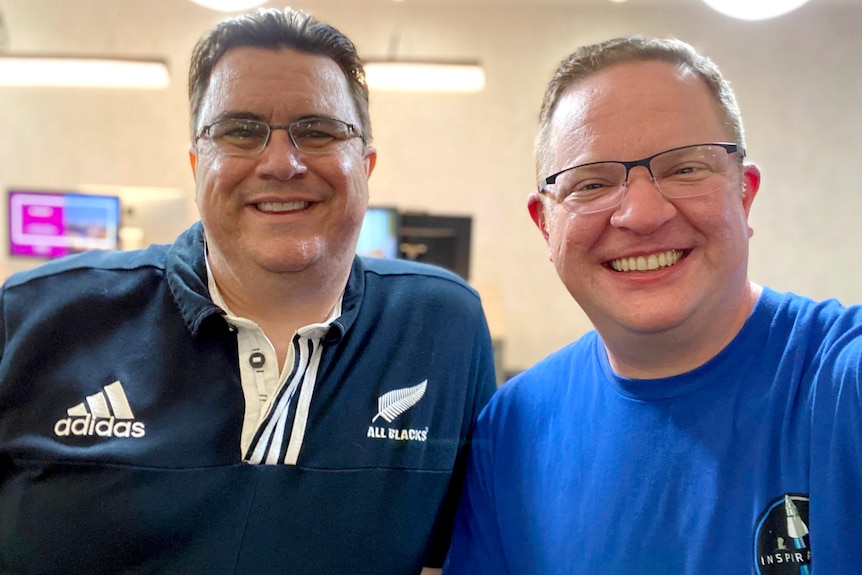 Head-and-shoulders shot of two men smiling at the camera