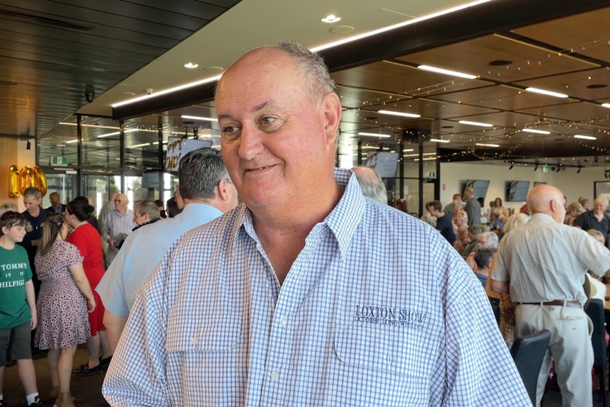 Ian Cass, a middle-aged grey balding man, in a chequered blue shirt with Loxton Show embroidered on the left breast.