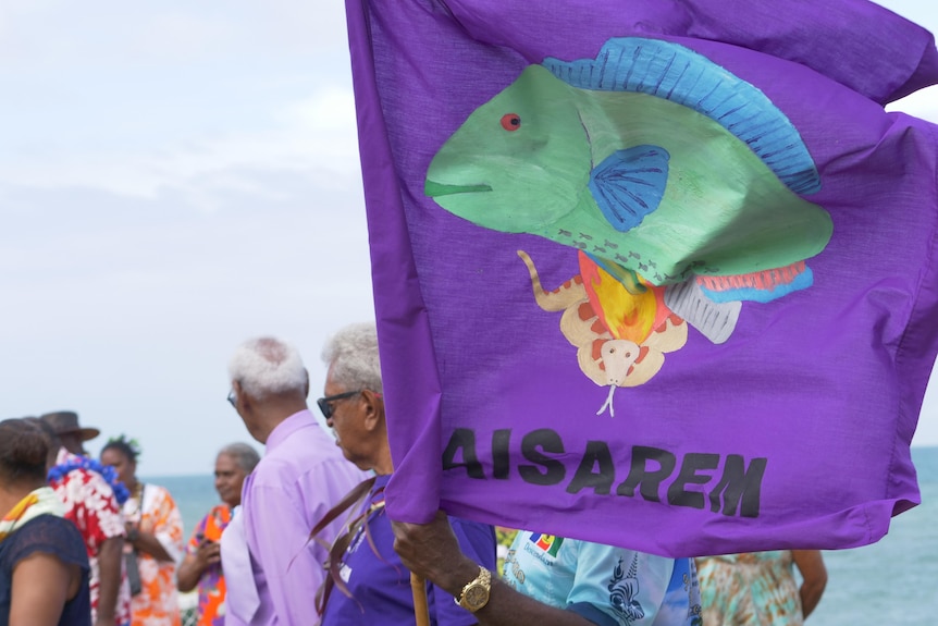 A purple flag with a picture of animals including a fish.