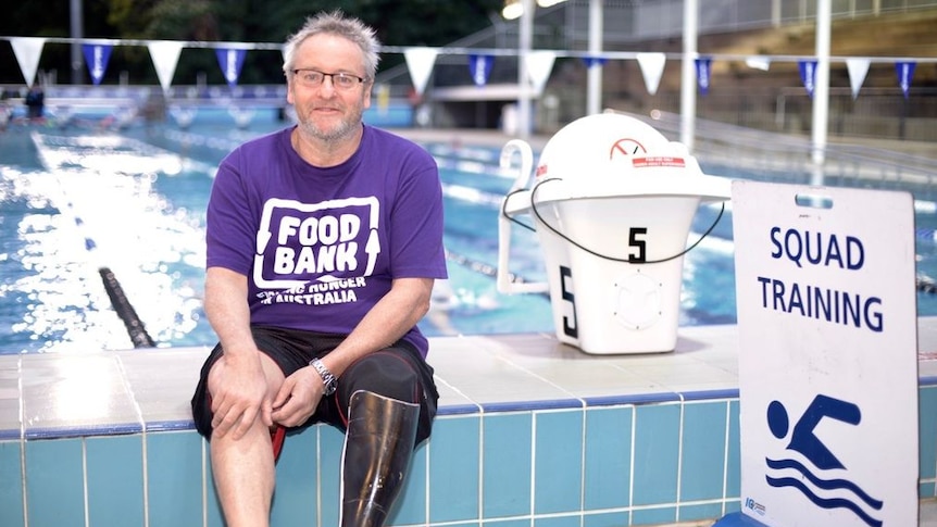 Amputee swimmer Michael Powell sits beside a swimming pool in Brisbane