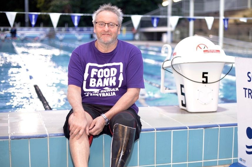 Amputee swimmer Michael Powell sits beside a swimming pool in Brisbane