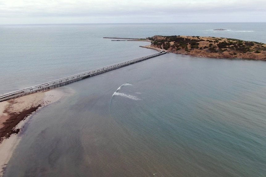 An overhead shot of a bridge connecting an island to the mainland