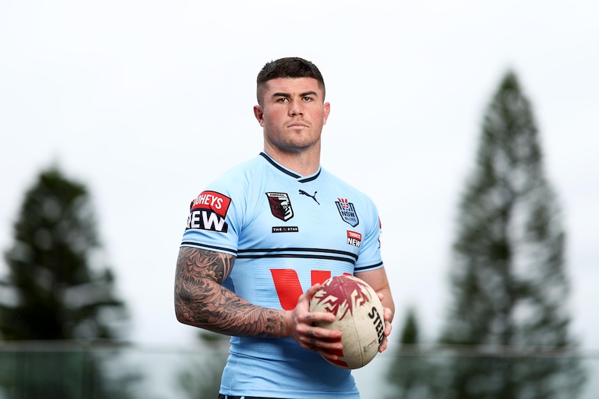 A man poses up in a rugby league jersey