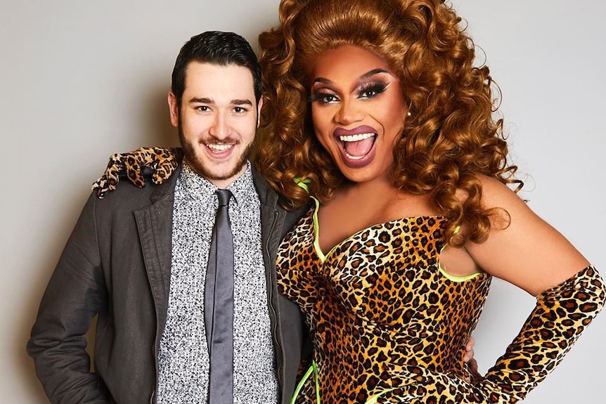 RuPaul's Drag Race contestant Brita wears a leopard print dress with green piping and matching elbow length gloves.