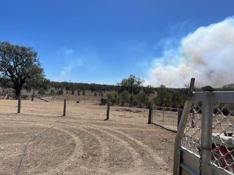 Smoke rises over the horizon from a grass fire burning 50 kilometres north of Inverell in the NSW. 