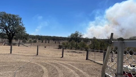 Smoke rises over the horizon from a grass fire burning 50 kilometres north of Inverell in the NSW. 