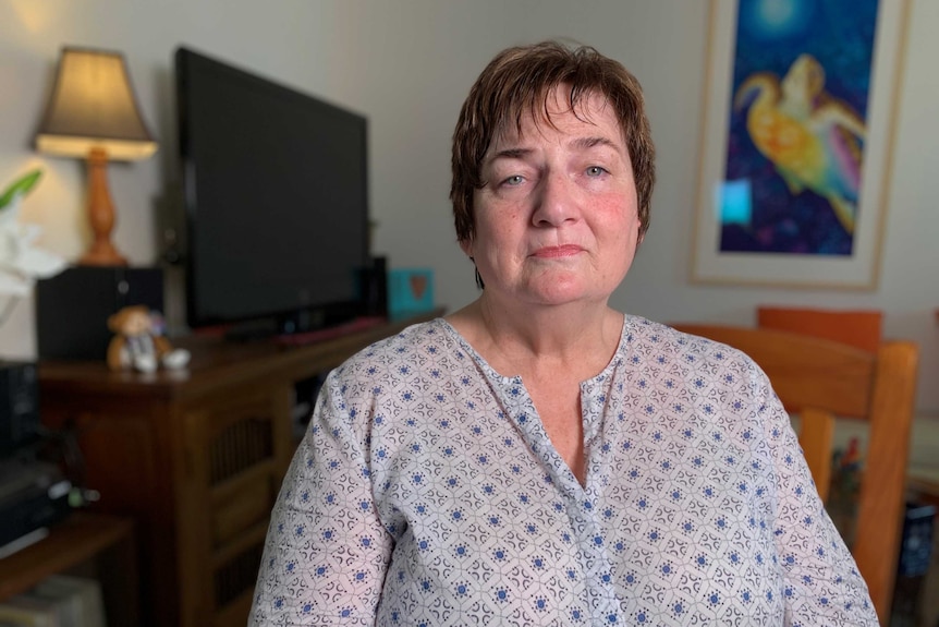 Louise King, ongoing pain from pelvic mesh, is seen in the lounge of her home.