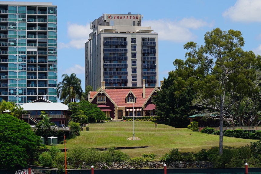 Shafston House from Brisbane River, in foreground, with lawn rising to red and white historic home behind