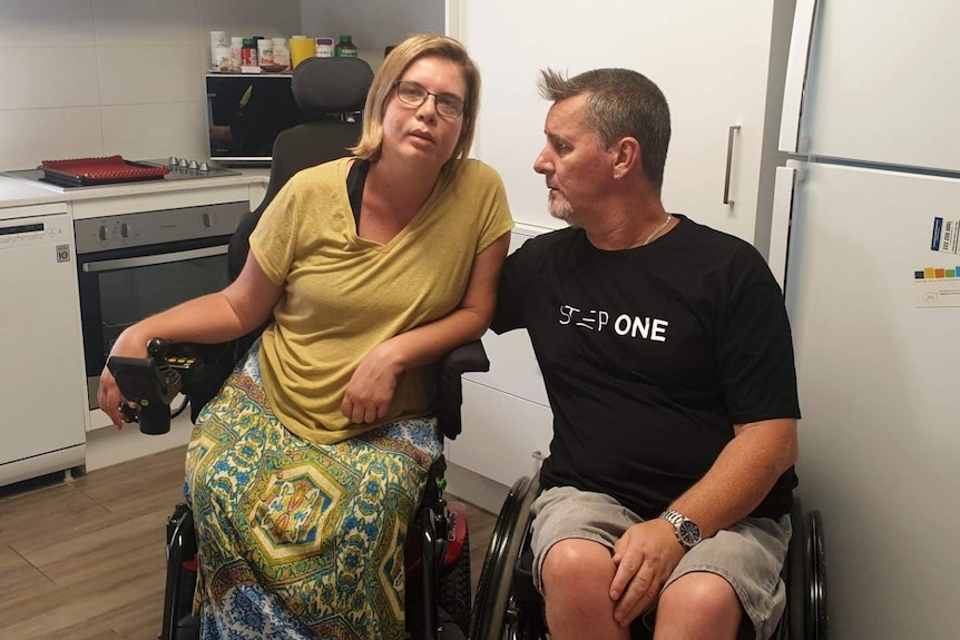 Kelly and Gordon Cox in their wheelchairs in a kitchen.