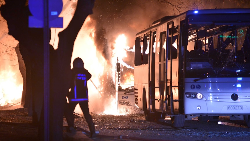 Fire fighters try to extinguish flames from a bus following the explosion.