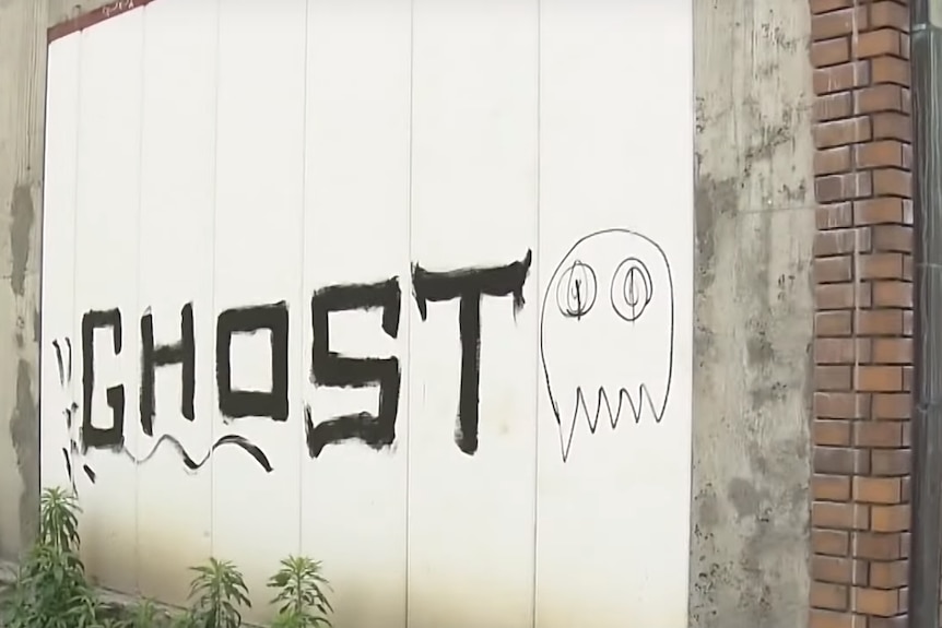A graffiti tag on a white wall reading "ghost"