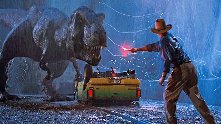 A man holds a flare to distract a dinosaur threatening a car