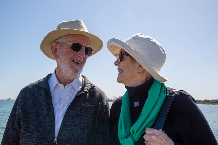 Barrie and Diana Pittock look at each other standing on the coast.