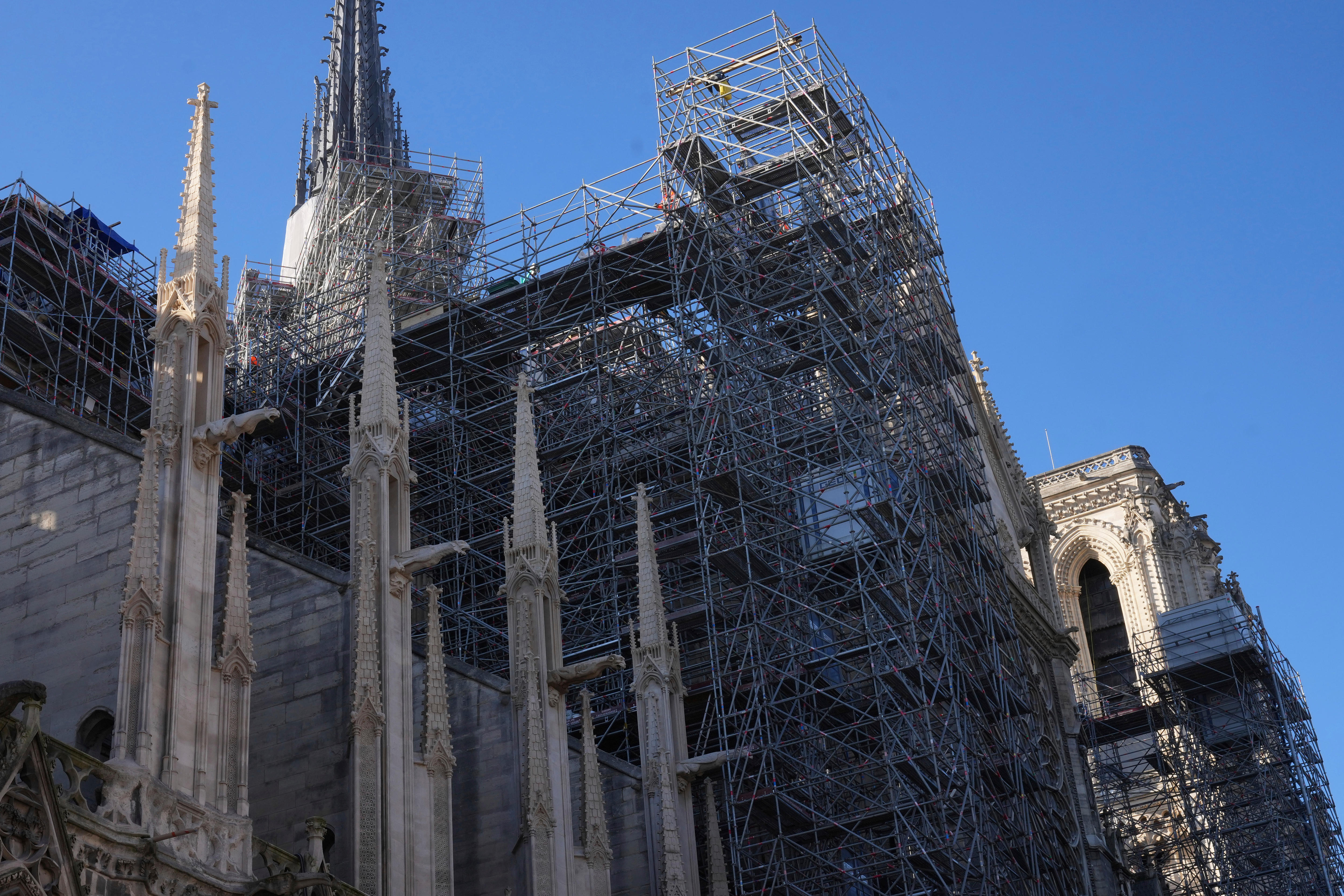Scaffolding around the Notre-Dame cathedral, backgrounded by blue sky