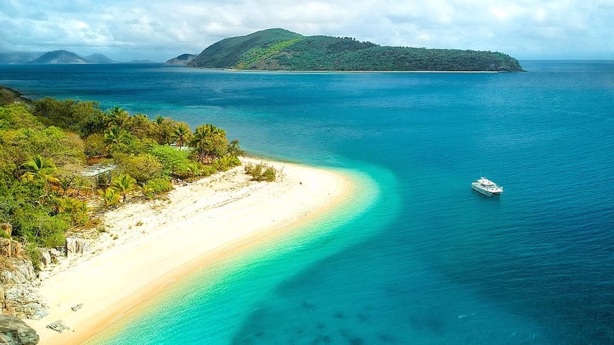 A bird's eye view of Orpheus Island overlooking white sandy beaches and crystal blue water.