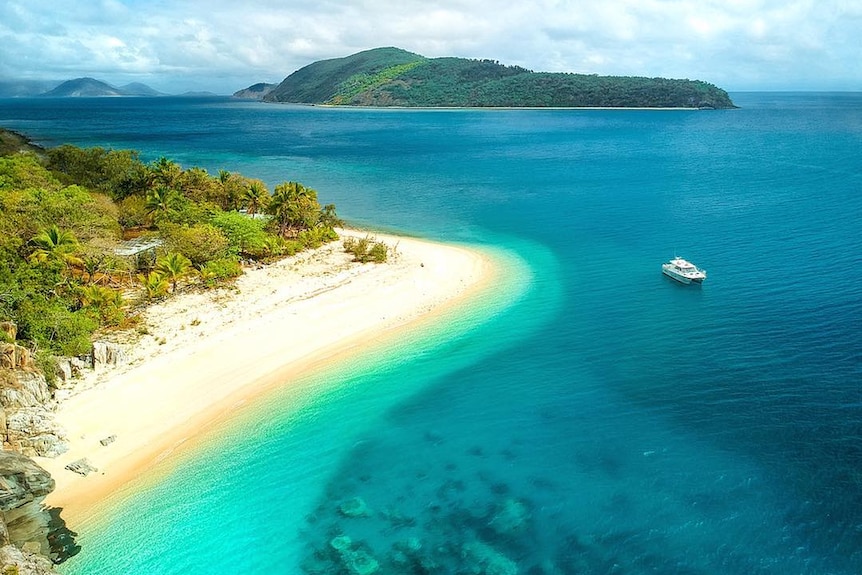 A bird's eye view of Orpheus Island overlooking white sandy beaches and crystal blue water.