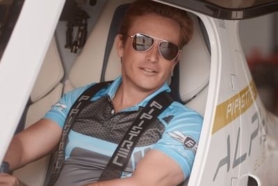 man wearing sunglasses sitting in small plane