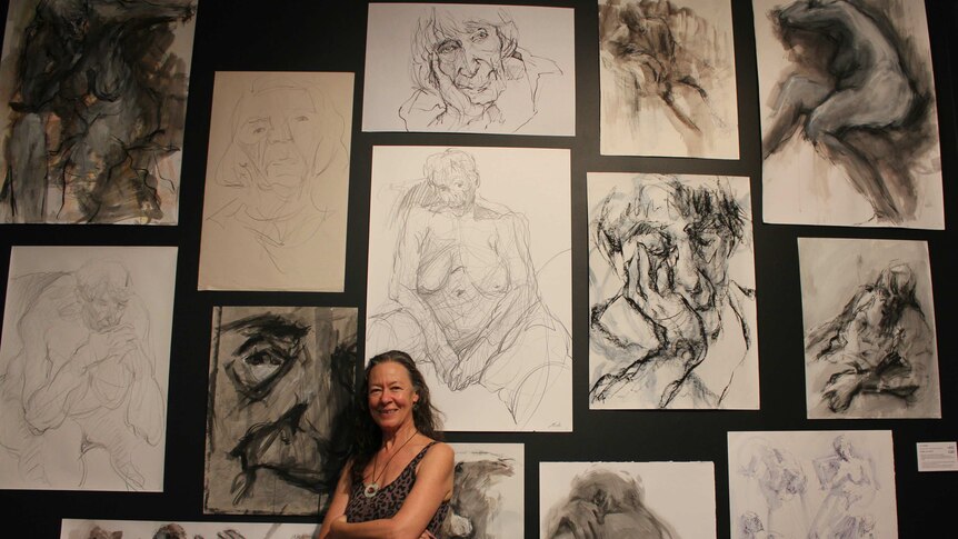 Artist Jo Ernst standing with body of work at Manning Regional Art Gallery.