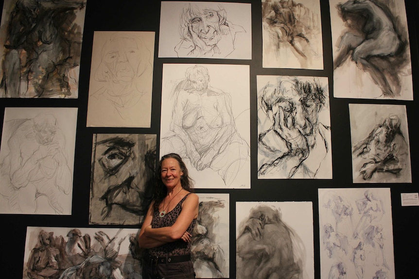 Artist Jo Ernst standing with body of work at Manning Regional Art Gallery.