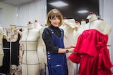 Leah Musch stands around mannequins while adjusting one of her pieces.