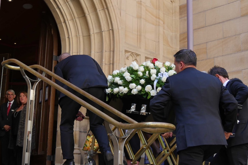 A group of men carried the coffin into the funeral.