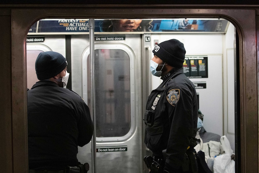 New York police officers wear masks while patrolling a subway in the Bronx.