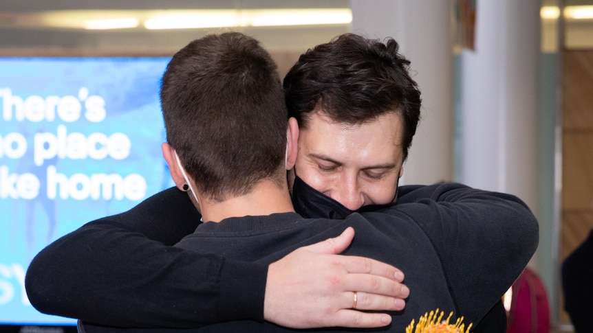 Friends hug in Sydney Airport when the first international flight touched down.