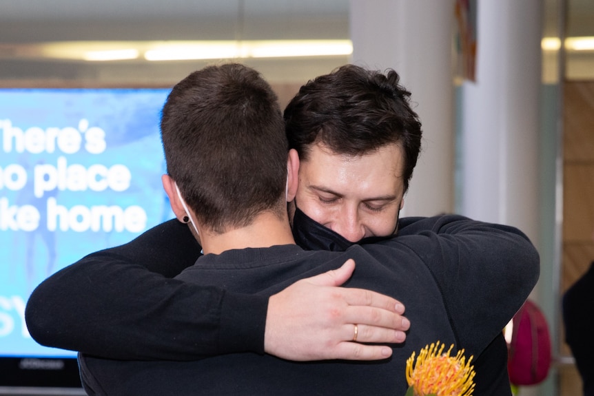 Friends hug in Sydney Airport when the first international flight touched down.