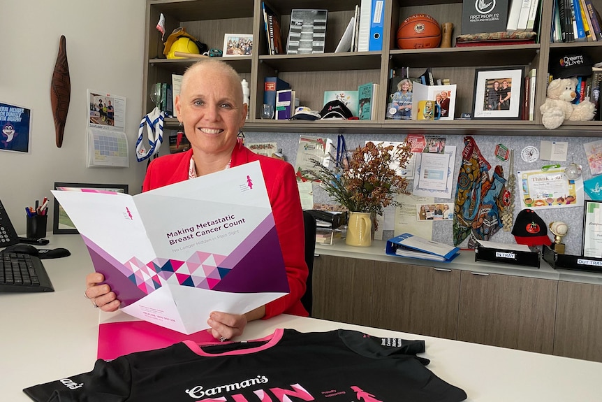 Peta Murphy looks at brochure about breast cancer awareness
