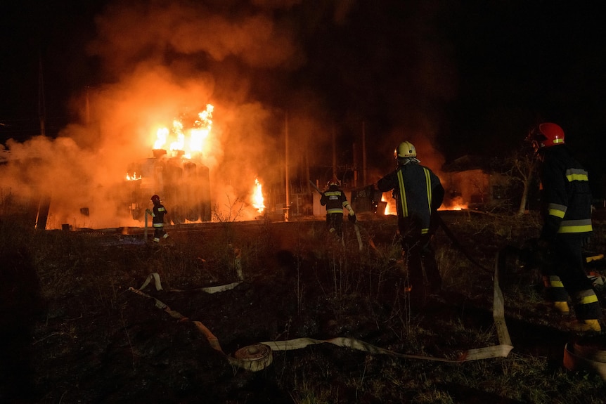 Firefighters work to put out fire at night.