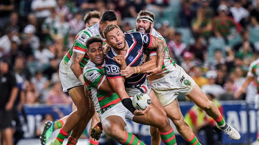 Jared Waerea-Hargreaves looks to offload while being tackled by South Sydney opponents.