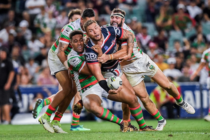 Jared Waerea-Hargreaves looks to offload while being tackled by South Sydney opponents.