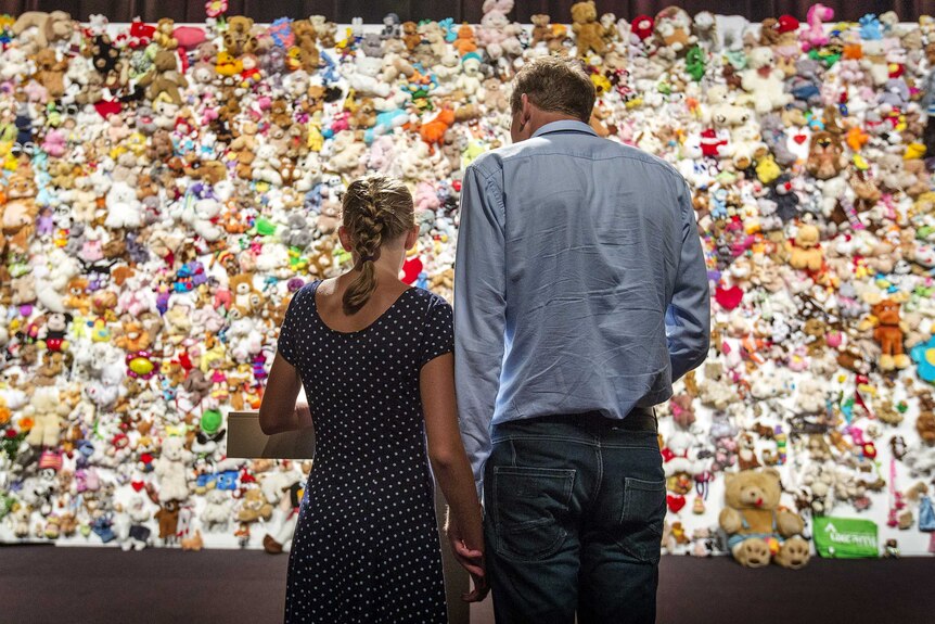 Family members and friends of victims gather in front of a "hedge of compassion", made of thousands of soft toys, during a commemoration ceremony for the victims of Malaysia Airlines flight MH17.
