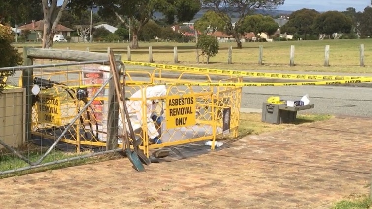 Worker removing asbestos from pit