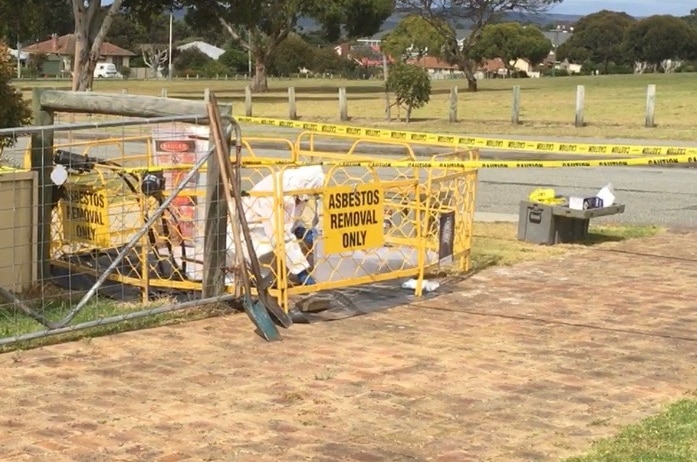 Worker removing asbestos from pit