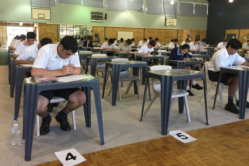 Seated in rows are year 12 Corpus Christi college in Bateman sit the 2014 physics exam